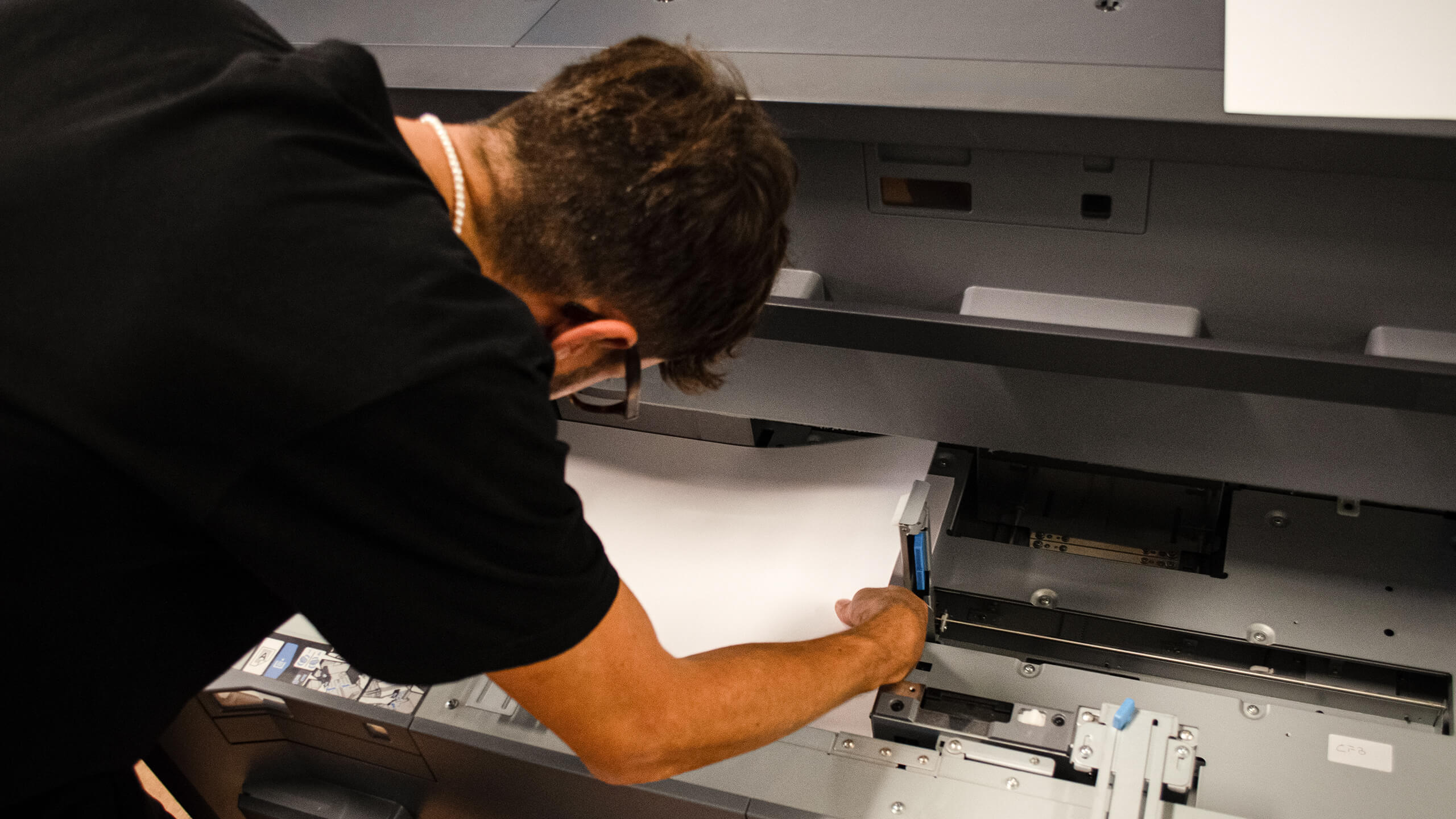 Un operatore carica la carta in una macchina da stampa digitale