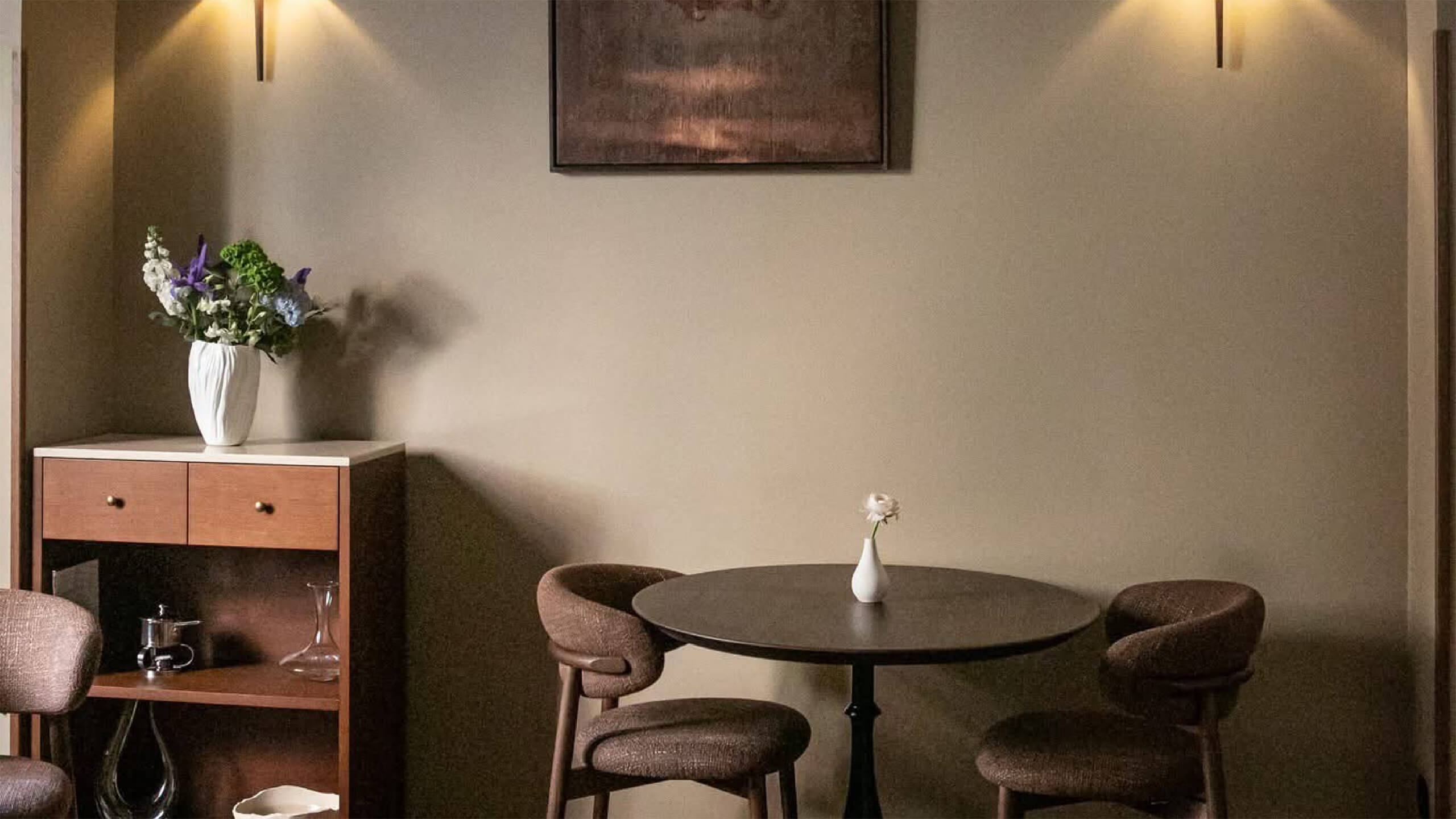 La sala del ristorante: l'arco, le due applique accese, il quadro, il tavolino rotondo con le sedie, la credenza con i fiori, Pulejo, Lion Brand