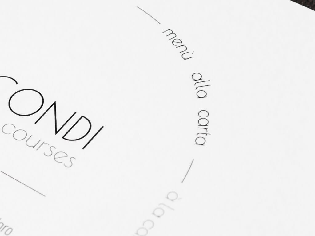 La pagina «Secondi» con l'arco di testo «menù alla carta / à la carte menu» e il bordo scuro della copertina, Pulejo, Lion Brand