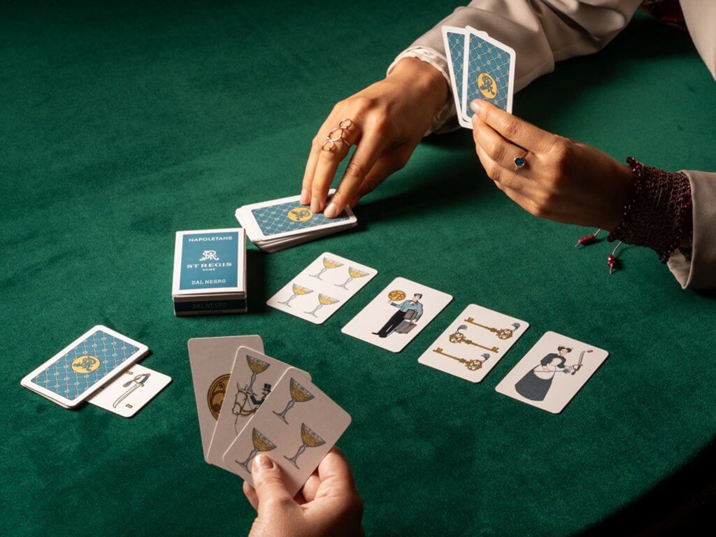 Mani e carte da gioco sul panno verde, kit di Natale del St. Regis, Lion Brand