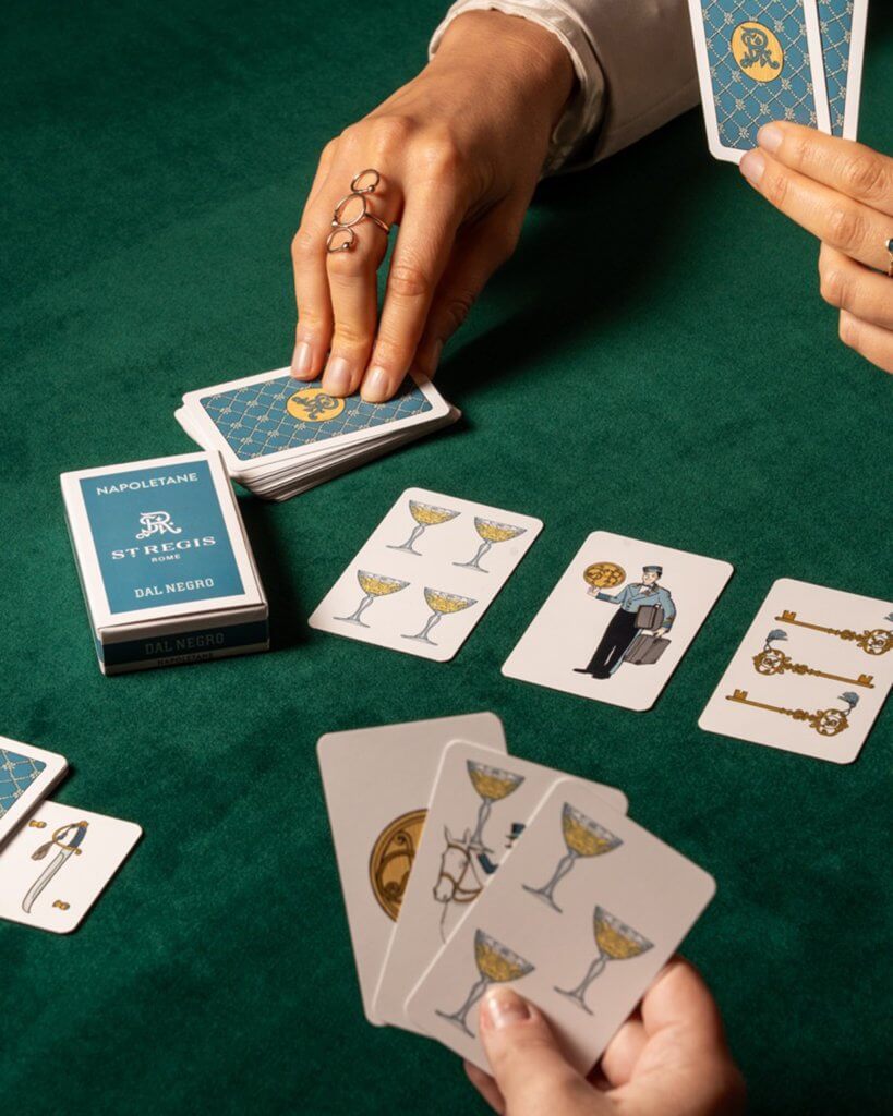 Una mano gioca le carte, kit di Natale del St. Regis, Lion Brand